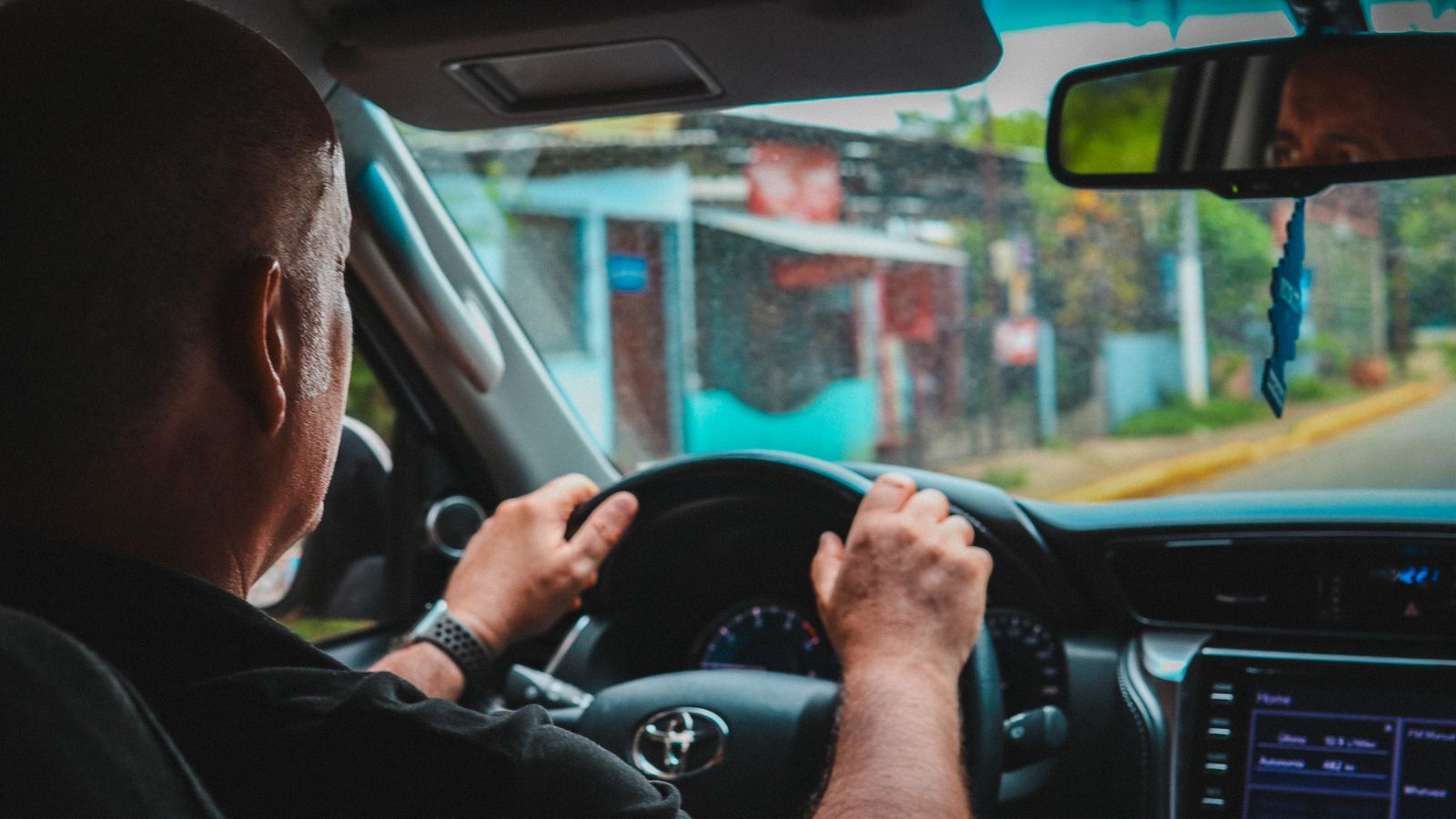 Oudere bestuurder zit achter het stuur van een auto